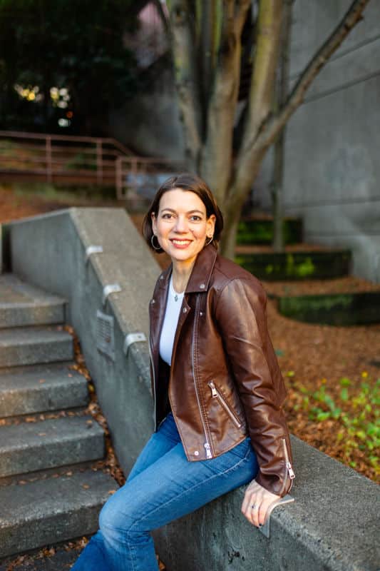 Photo of Laura Jawad sitting my some stairs in jeans and a leather jacket.